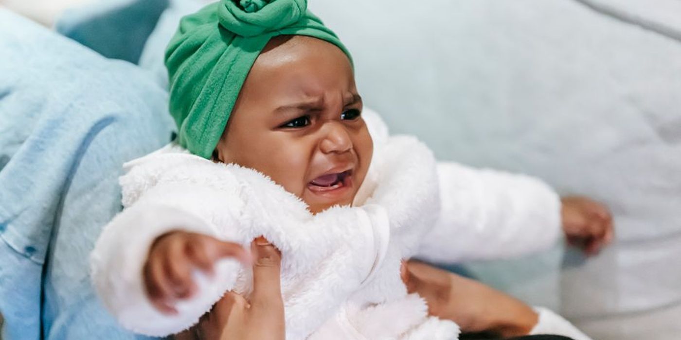 Bayi menangis didukung ibu bapa